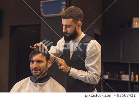 Male hairdresser working with the client in the babershop Male hairdresser working with the client in the babershop 98568421