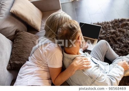 Man and woman watching something online together Man and woman watching something online together 98568469