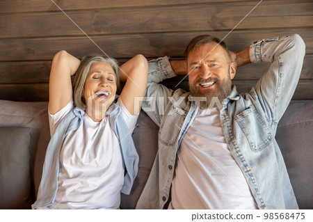 Mid aged man and woman laying on bed and looking peaceful and relaxed 98568475
