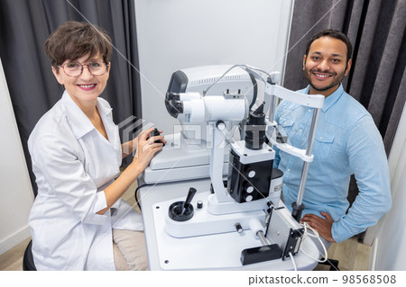 Optometrist in white scubs near refractometer 98568508