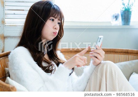 生氣和使用智能手機的年輕女人 98568516