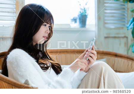 Young woman angry and using smartphone 98568520