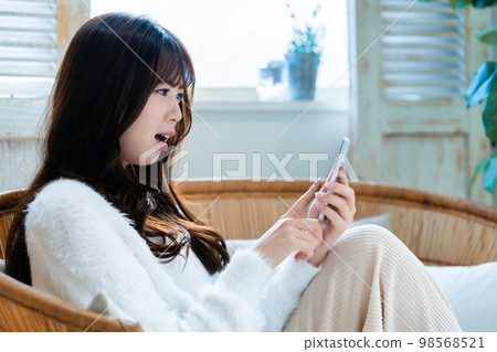 Young woman angry and using smartphone Young woman angry and using smartphone 98568521