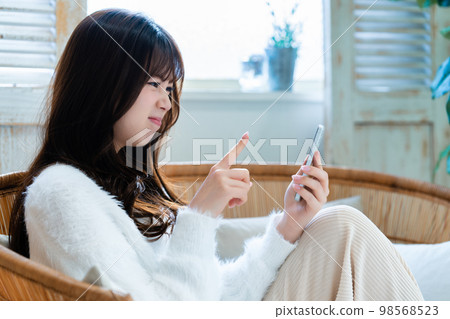 Young woman angry and using smartphone Young woman angry and using smartphone 98568523