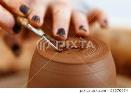 Female hands hold a bowl for casting clay products. Shaped method for making clay dishes. Handwork. Pottery making.Close up Female hands hold a bowl for casting clay products. Shaped method for making clay dishes. Handwork. Pottery making.Close up 98570974