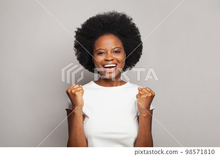 Beautiful young woman in white t-short having fun against grey studio wall background 98571810