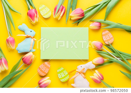 Template for Easter greeting card. Easter festive frame with eggs, tulips and easter bunny 98572050