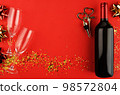 Still life with a bottle of wine, a corkscrew and a cork with heart-shaped handle on red background. View from above. 98572804