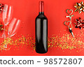 Still life with a bottle of wine, a corkscrew and a cork with heart-shaped handle on red background. View from above. 98572807