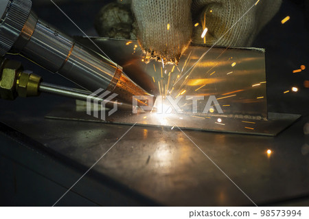 Close up scene the welding process with the sparking light. 98573994