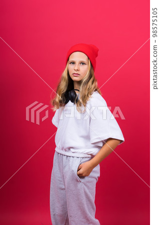 Child music concept. Teenager girl dances in rhythm of melody, listens song in headphones 98575105