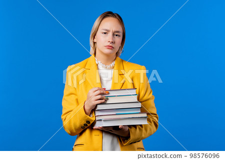 Lazy student woman is dissatisfied with amount of books homework on blue Lazy student woman is dissatisfied with amount of books homework on blue 98576096