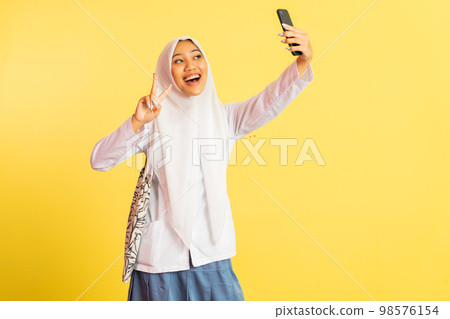 girl in veil selfie using smartphone with v-sign hand gesture girl in veil selfie using smartphone with v-sign hand gesture 98576154