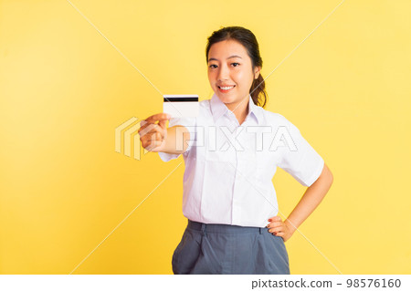Smiling high school girl holding blank card on isolated background Smiling high school girl holding blank card on isolated background 98576160