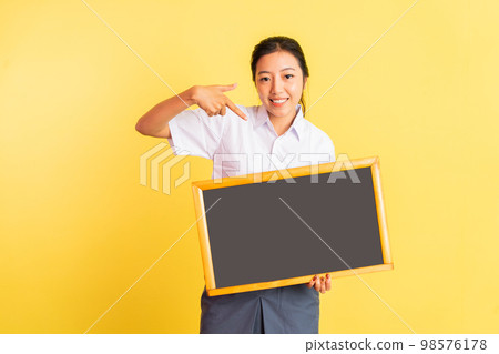 girl in high school uniform holding blackboard with pointing finger 98576178