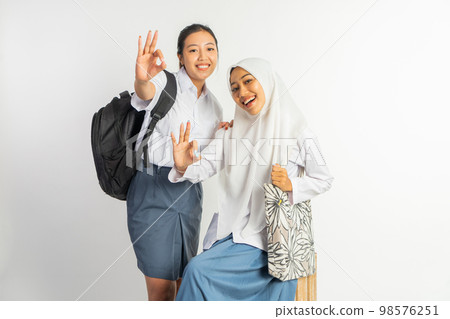 two smiling vocational high school girls with ok hand gesture two smiling vocational high school girls with ok hand gesture 98576251