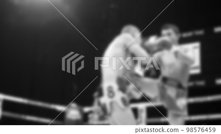 Blurred images black and white photo style of Thai boxing or Muay Thai or Kickboxing which local and foriegn boxer are fighting on the ring at indoor stage as martial art sport. Muay Thai Kick boxing Blurred images black and white photo style of Thai boxing or Muay Thai or Kickboxing which local and foriegn boxer are fighting on the ring at indoor stage as martial art sport. Muay Thai Kick boxing 98576459