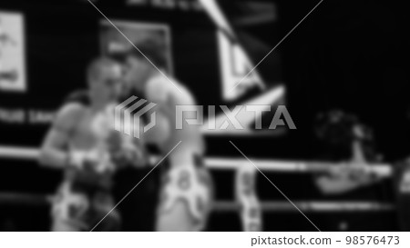 Blurred images black and white photo style of Thai boxing or Muay Thai or Kickboxing which local and foriegn boxer are fighting on the ring at indoor stage as martial art sport. Muay Thai Kick boxing Blurred images black and white photo style of Thai boxing or Muay Thai or Kickboxing which local and foriegn boxer are fighting on the ring at indoor stage as martial art sport. Muay Thai Kick boxing 98576473