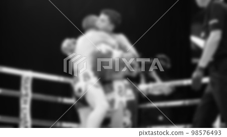 Blurred images black and white photo style of Thai boxing or Muay Thai or Kickboxing which local and foriegn boxer are fighting on the ring at indoor stage as martial art sport. Muay Thai Kick boxing Blurred images black and white photo style of Thai boxing or Muay Thai or Kickboxing which local and foriegn boxer are fighting on the ring at indoor stage as martial art sport. Muay Thai Kick boxing 98576493