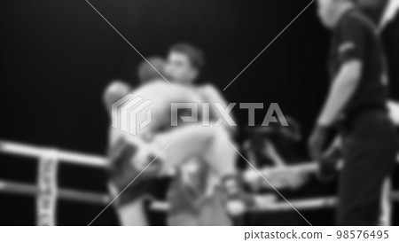 Blurred images black and white photo style of Thai boxing or Muay Thai or Kickboxing which local and foriegn boxer are fighting on the ring at indoor stage as martial art sport. Muay Thai Kick boxing Blurred images black and white photo style of Thai boxing or Muay Thai or Kickboxing which local and foriegn boxer are fighting on the ring at indoor stage as martial art sport. Muay Thai Kick boxing 98576495