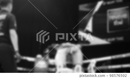 Blurred images black and white photo style of Thai boxing or Muay Thai or Kickboxing which local and foriegn boxer are fighting on the ring at indoor stage as martial art sport. Muay Thai Kick boxing 98576502