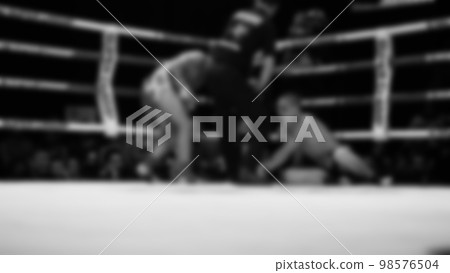 Blurred images black and white photo style of Thai boxing or Muay Thai or Kickboxing which local and foriegn boxer are fighting on the ring at indoor stage as martial art sport. Muay Thai Kick boxing 98576504