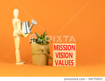Mission vision values symbol. Concept words Mission Vision Values on wooden blocks on a beautiful orange table orange background. Businessman icon. Business mission vision values concept. Copy space. Mission vision values symbol. Concept words Mission Vision Values on wooden blocks on a beautiful orange table orange background. Businessman icon. Business mission vision values concept. Copy space. 98576903