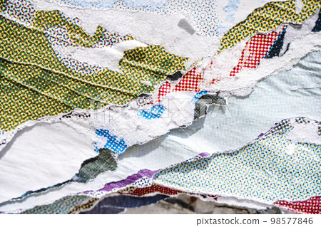 Torn paper collage background on an old poster on a street wall. Texture and surface of torn paper. Torn paper collage background on an old poster on a street wall. Texture and surface of torn paper. 98577846