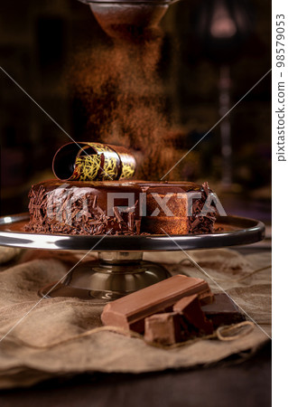 Chocolate biscuit cake with buttercream and ganache sprinkled with cocoa Chocolate biscuit cake with buttercream and ganache sprinkled with cocoa 98579053
