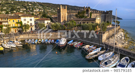 Scenic places of beautiful lake Lago di Garda. aerial view of charming village Torri del Benaco over sunset . Italy, Verona province Scenic places of beautiful lake Lago di Garda. aerial view of charming village Torri del Benaco over sunset . Italy, Verona province 98579185