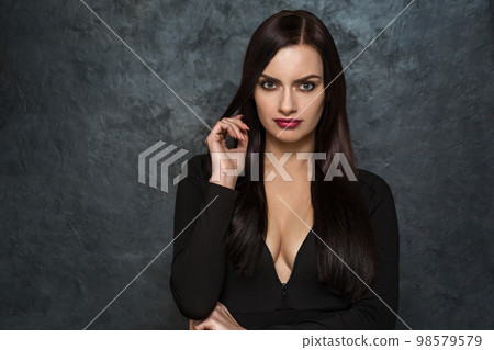 A dark-haired woman in a black dress 98579579