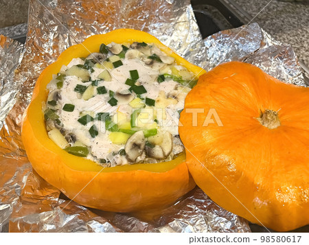 Roast chicken with mushrooms and cheese in baked pumpkin Roast chicken with mushrooms and cheese in baked pumpkin 98580617