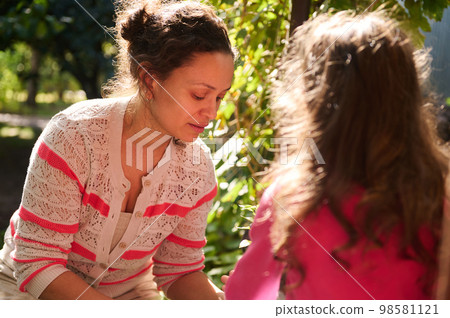 Mother and daughter planting seedlings in early spring day at beautiful sunset. Agriculture. Gardening. Farming concept 98581121