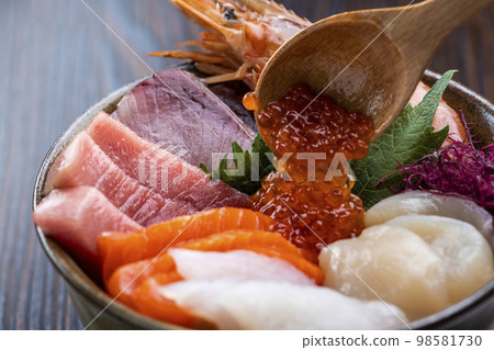 Put salmon roe on seafood bowl 98581730
