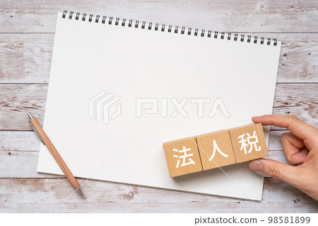 corporate tax written block, notebook, pen and hand corporate tax written block, notebook, pen and hand 98581899