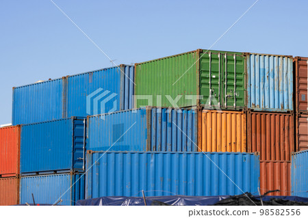 Multicolored cargo containers on a blue sky background Multicolored cargo containers on a blue sky background 98582556