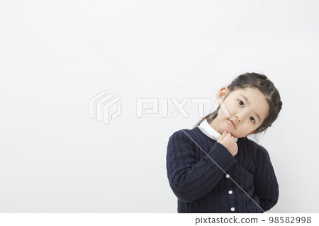A child girl on a white background who is worried or thinking 98582998