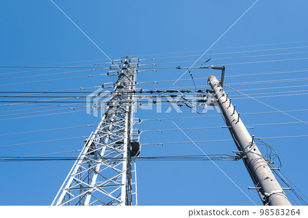 Power transmission towers that support electric wires and high-voltage transmission lines in residential areas and clear skies Cool colors Power transmission towers that support electric wires and high-voltage transmission lines in residential areas and clear skies Cool colors 98583264
