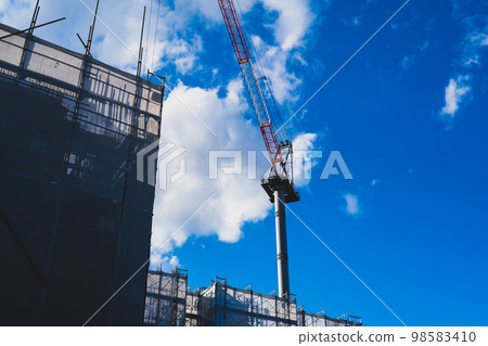 建設中的公寓，高聳的起重機和白雲 a-2 高飽和度啞光 98583410