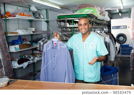 Portrait of male worker of dry-cleaning facility Portrait of male worker of dry-cleaning facility 98583479