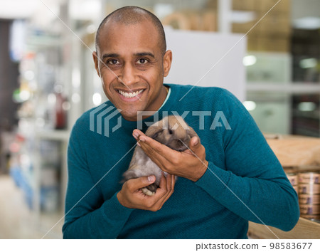 Man holding cute rabbit in pet shop 98583677