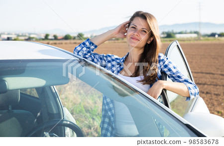 Portrait of driver caucasian woman next to car 98583678