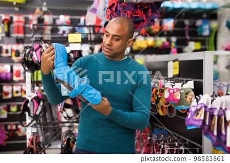 Man choosing dog clothes in pet shop 98583861