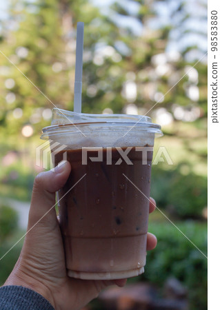 Woman hold her iced coffee Woman hold her iced coffee 98583880