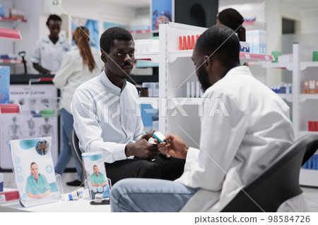 Pharmacy consultation, african american patient measuring glucose with glucometer, diabetes diagnosis in drugstore. Blood sugar level control, medical service, healthcare Pharmacy consultation, african american patient measuring glucose with glucometer, diabetes diagnosis in drugstore. Blood sugar level control, medical service, healthcare 98584726