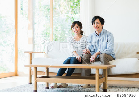 A young couple relaxing in the living room A young couple relaxing in the living room 98584936