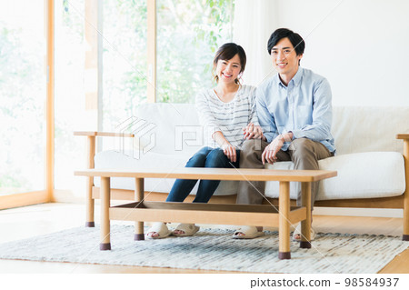 A young couple relaxing in the living room 98584937