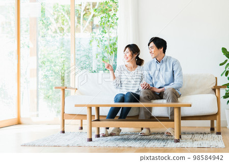 A young couple relaxing in the living room A young couple relaxing in the living room 98584942