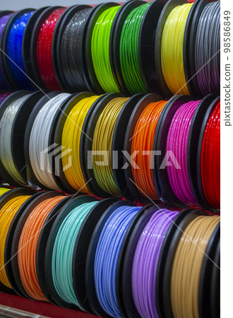 Many multi-colored spools of thread of filament for printing 3d printer. Material coils for printing 3D printer. Spools of 3D printing motley different colors filament. ABS wire plastic for 3d printer Many multi-colored spools of thread of filament for printing 3d printer. Material coils for printing 3D printer. Spools of 3D printing motley different colors filament. ABS wire plastic for 3d printer 98586849
