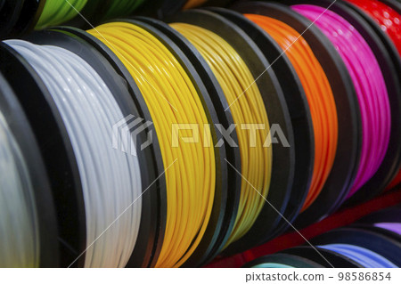Many multi-colored spools of thread of filament for printing 3d printer. Material coils for printing 3D printer. Spools of 3D printing motley different colors filament. ABS wire plastic for 3d printer 98586854
